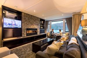 sala de estar con sofá y chimenea en Commonage Villas by Staysouth, en Queenstown