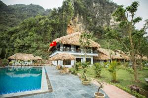 un complejo con piscina y montaña de fondo en Tam Coc Rice Fields Resort, en Ninh Binh