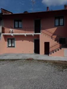 a pink house with a balcony and stairs at Appartamento Ormeni in Cardano al Campo