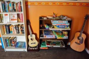 dos guitarras y un estante de libros con libros en Blue Moon Lodge, en Havelock