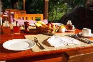 a table with a plate of food and a basket of fruit at Windermere Estate in Munnar