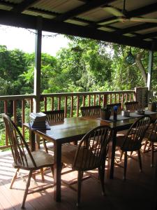 a wooden table and chairs on a deck at Mossman Gorge Bed and Breakfast in Mossman