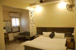 a hotel room with a bed and a table and a chair at Hotel New Sunder in Indore