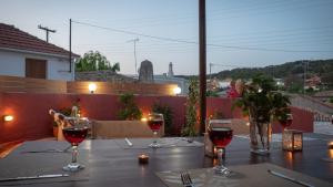a table with three glasses of red wine on it at Vorto House in Agios Leon