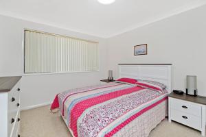 Schlafzimmer mit einem Bett, einem Schreibtisch und einem Fenster in der Unterkunft Quarterdeck 7 7 Stewart Street in Port Macquarie