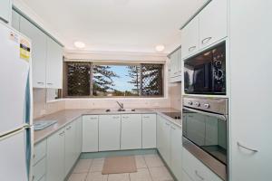 uma cozinha branca com um lavatório e uma janela em Quarterdeck 7 7 Stewart Street em Port Macquarie
