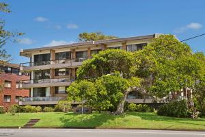 um prédio de apartamentos com uma árvore em frente em Quarterdeck 7 7 Stewart Street em Port Macquarie