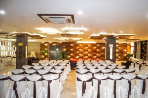 a banquet hall with rows of tables and chairs at Hotel Darshan SP Ring Road in Naroda