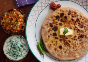 a plate of food with a stack of pancakes and dip at Sumikshas Homestay in Pedong