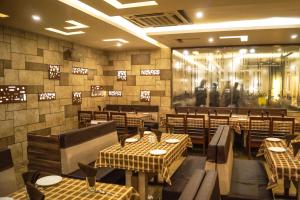 NarodaHotel Darshan SP Ring Road的一间有桌椅的餐厅