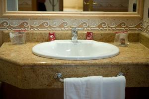 a white sink sitting under a mirror in a bathroom at Hotel La Maruxiña in La Alameda de la Sagra