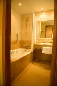 ein Badezimmer mit einer Badewanne und einem Waschbecken in der Unterkunft Hotel La Maruxiña in La Alameda de la Sagra