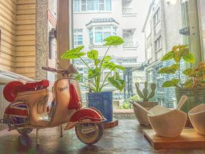 的住宿－銅鑼有一種慢．慢民宿 ，停在有植物的窗户前的摩托车