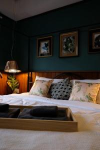 ein großes Bett in einem Zimmer mit grünen Wänden in der Unterkunft TANA CASA 12 Large Sathorn 6BR Townhome with Parking in Bangkok