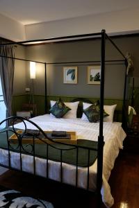 Schlafzimmer mit einem großen Bett mit Metallrahmen in der Unterkunft TANA CASA 12 Large Sathorn 6BR Townhome with Parking in Bangkok