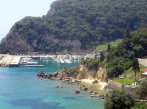 un gruppo di barche è ormeggiato in una spiaggia di Anthimos Rooms a Paleokastritsa