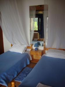 a bedroom with two beds and a window at Anthimos Rooms in Paleokastritsa