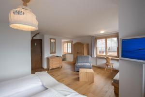 ein Wohnzimmer mit einem Bett und einem TV in der Unterkunft Hotel Postigliun Andiast in Andest