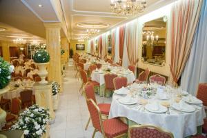 a row of tables in a restaurant with white table settings at Hotel La Maruxiña in La Alameda de la Sagra