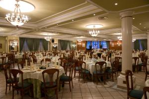 a banquet hall with tables and chairs and chandeliers at Hotel La Maruxiña in La Alameda de la Sagra