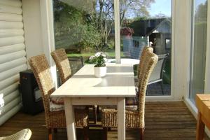 a table and chairs on a porch with a table and a window at Woody B&B in Jelling