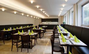 a dining room with tables and chairs with yellow napkins at Akademie der Dioezese in Stuttgart