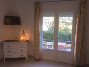 a room with a door and a dresser and a window at Villa Macoran 2 étoiles in Saint-Aygulf
