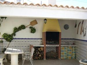 a outdoor kitchen with a fireplace and a table and chairs at Casa Rural La Noria in La Escucha