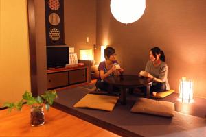 two women sitting around a table in a room at K's House Takayama [1st K's Hostel] in Takayama