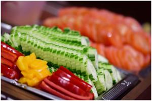 a tray of vegetables on a table with other vegetables at Motel Plus Berlin in Berlin