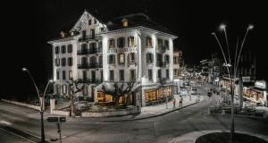 a large white building on a city street at night at Langley Hotel Gustavia in Chamonix