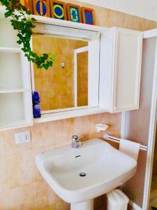 y baño con lavabo blanco y espejo. en Casa Vacanze Santa Perpetua, en Tirano