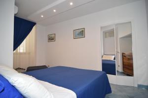 ミノーリにあるTac Tac Apartmentのベッドルーム(青いベッド1台、鏡付)