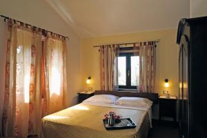 サンタンドレーア・アポストロ・デッロ・イオーニオにあるB&B L'Oasiのベッドルーム1室(トレイ付きベッド1台付)