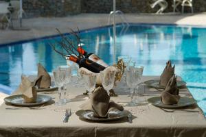 Corali Resort في أغرينيو: طاولة مع كؤوس وزجاجة من النبيذ عليها