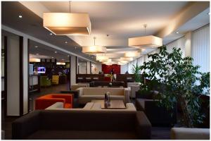 a waiting room with couches and tables and lights at Motel Plus Berlin in Berlin
