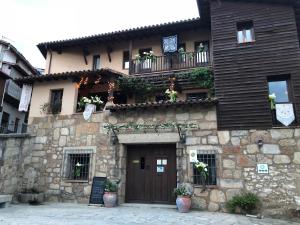 a stone building with a wooden door and a balcony at Casa Rural La Picota in Valverde de la Vera