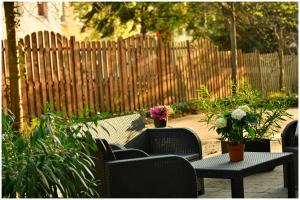 a patio with chairs and tables with flowers and a fence at Motel Plus Berlin in Berlin