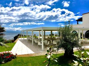 a gazebo with tables and chairs on the beach at Hotel Punta Negra in Alghero