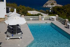 a pool with two lounge chairs and an umbrella at 9 Muses Exclusive Apartments in Grikos