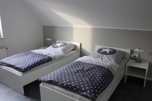 2 nebeneinander sitzende Betten in einem Schlafzimmer in der Unterkunft FeWo-Nordwalde in Nordwalde