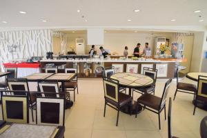 a restaurant with tables and people in the kitchen at Hotel Tavern Surigao in Surigao