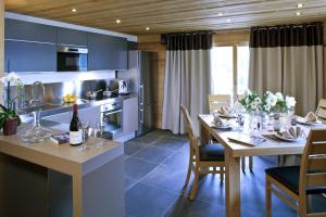 - une cuisine et une salle à manger avec une table et des chaises dans l'établissement Chalet Marin, au Grand-Bornand