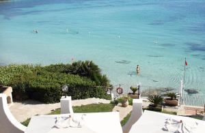 a view of a beach with people in the water at Hotel Punta Negra in Alghero