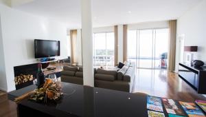 a living room with a couch and a tv at OurMadeira - Fonte do Mar 1, premium in Caniço