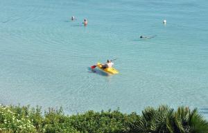 a group of people swimming in the water at Hotel Punta Negra in Alghero