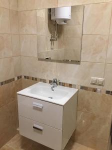 ein Badezimmer mit einem weißen Waschbecken und einem Spiegel in der Unterkunft Apartment Viva in Kiew