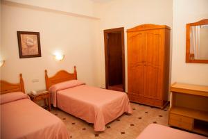 Postel nebo postele na pokoji v ubytování Hostal París