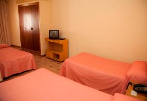 Postel nebo postele na pokoji v ubytování Hostal París