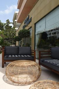 a table and two benches in front of a store at Villa Orion Hotel in Athens